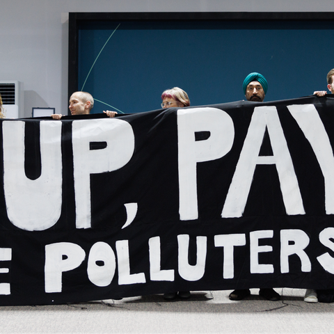 Activists are holding a giant banner at COP29 that says 'Pay up, Pay up, Make polluters pay'