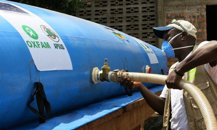 Modeste Mirindi connects the bladder to the taps of the new water point of the Elim Church in Bimbo, Central African Republic.